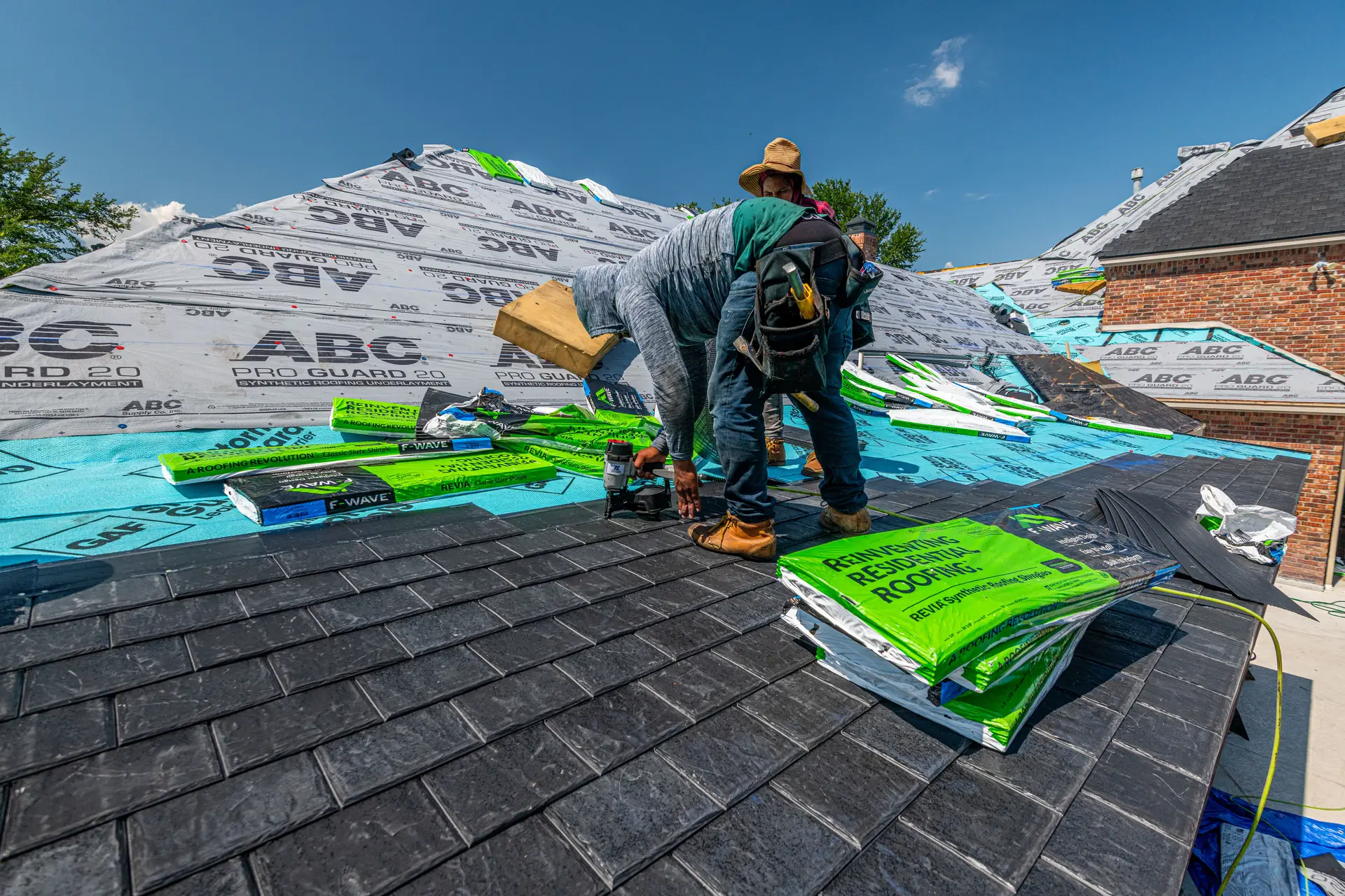 Roofers installing new shingles over underlayment